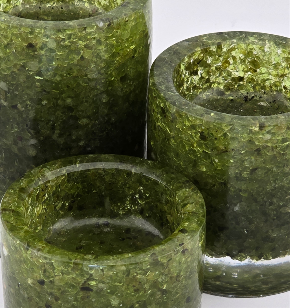 Three green peridot tea light candle holders on a white background - close-up