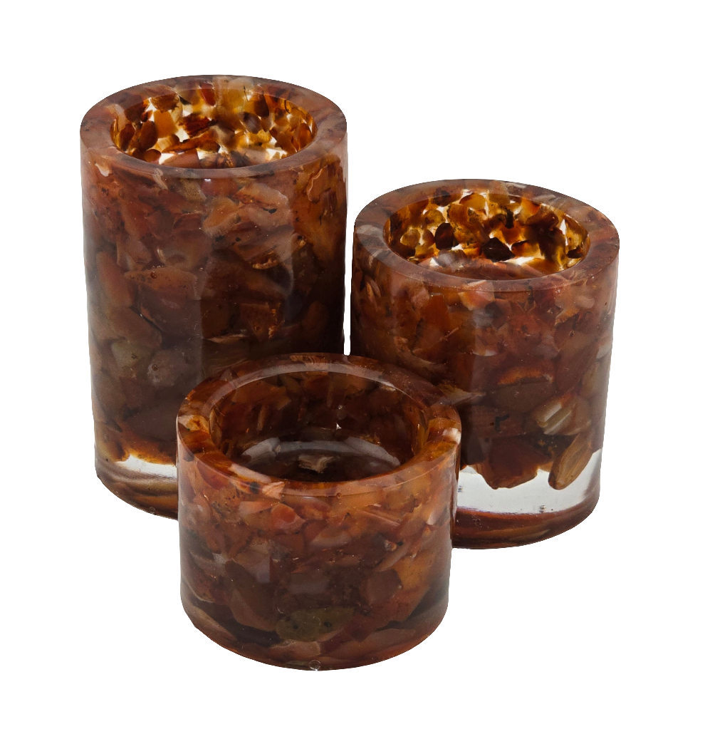 Three Carnelian semi-precious gemstone tea light candle holders on a white background. No candles