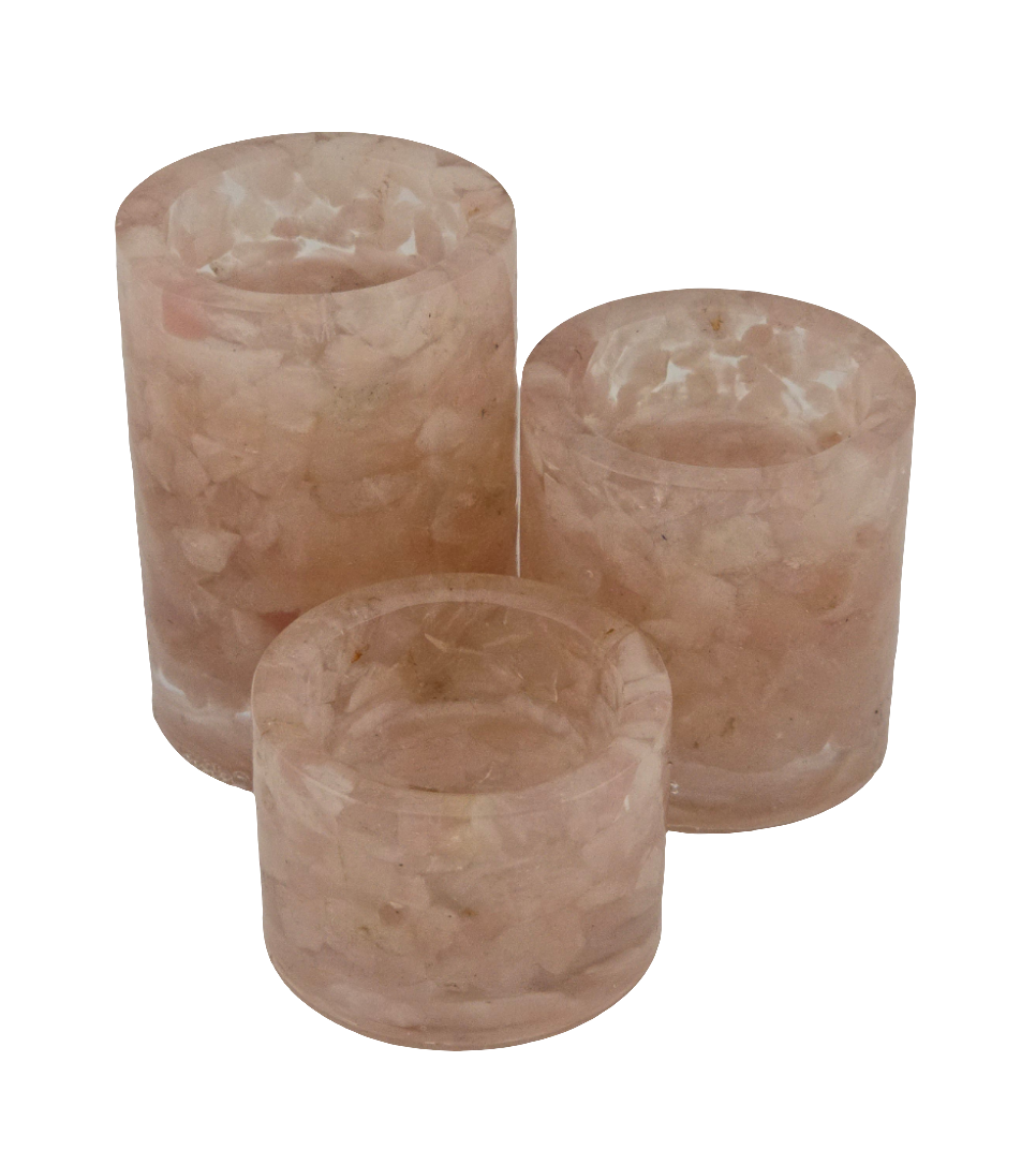 Three cylindrical Rose Quartz tea light holders on a white background