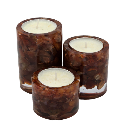 Set of three Carnelian semi-precious gemstone tea light candle holders with white candles on a white background