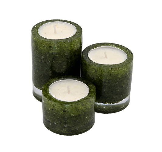 Three green peridot tea light candle holders with white candles on a white background