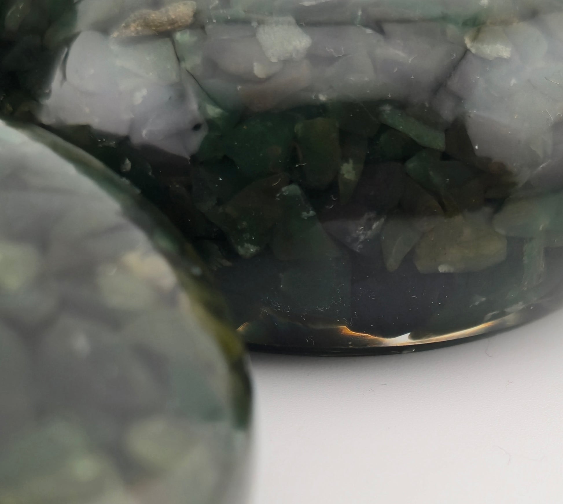 Close-up of green Aventurine stone tea light holders on a white surface