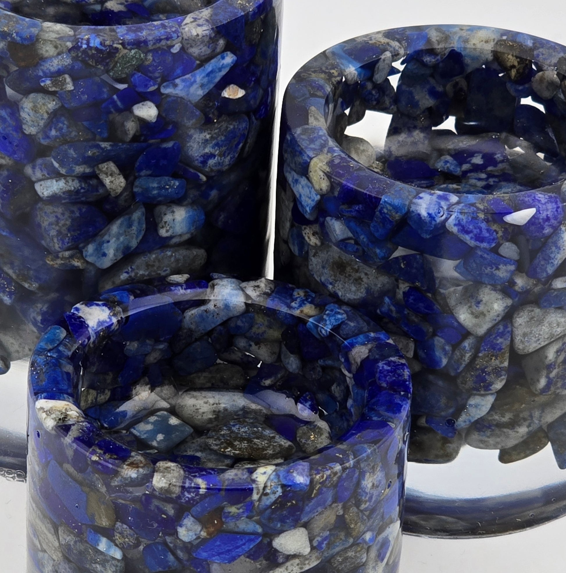 Three decorative Lapis Lazuli tea light candle holders on a white background. Close-up